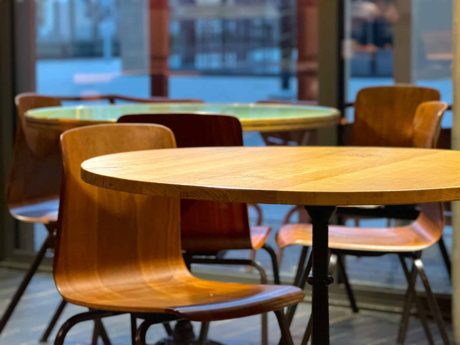 Restaurant interior with round timber tables and chairs