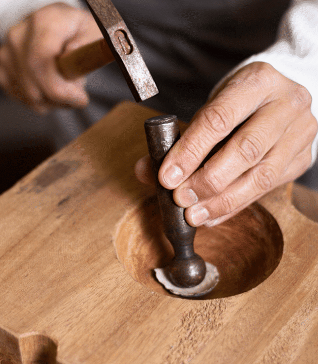 Craftsman shaping a timber piece by hand